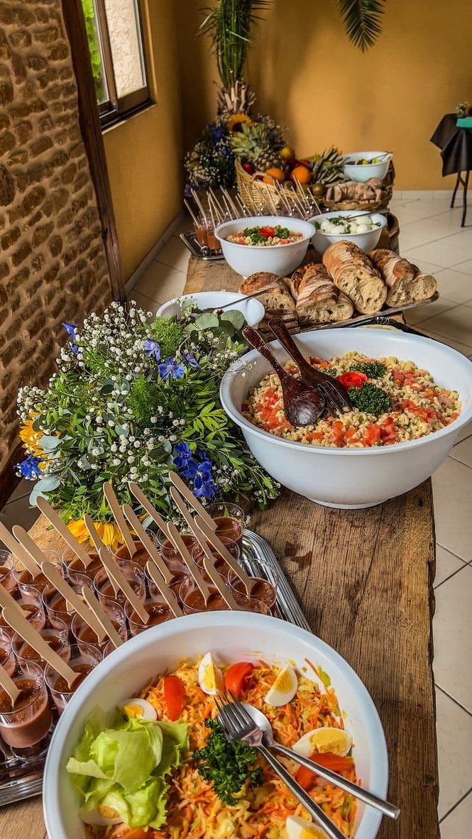 Buffet de salades composées et de brochettes décoré de fleurs