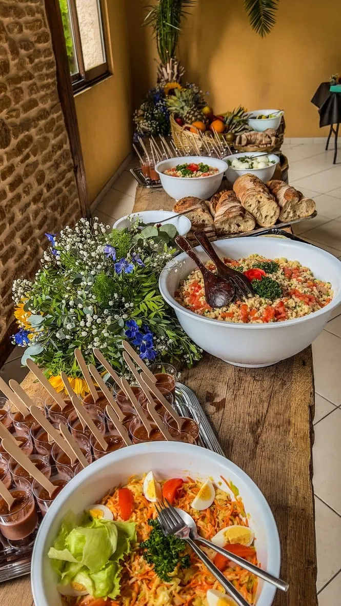 Buffet de salades composées et de brochettes décoré de fleurs